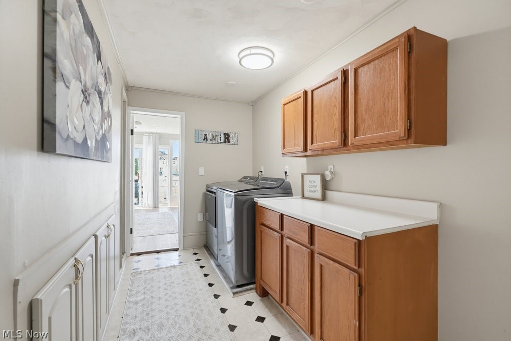 23055 Snell Road Columbia Station, OH 44028 - Photo 29 of 50 Laundry area featuring wood-finish cabinetry, white countertops, and patterned flooring