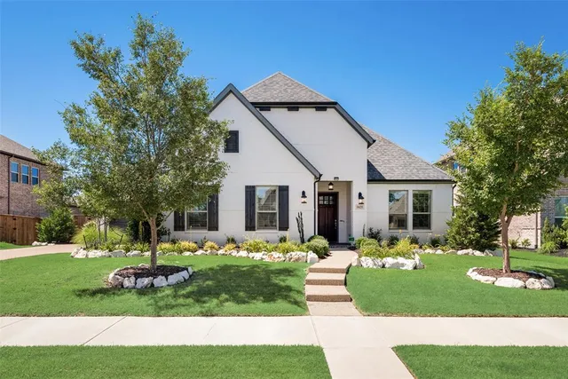 a front view of house with a garden and trees