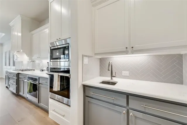 a kitchen with granite countertop white cabinets and stainless steel appliances