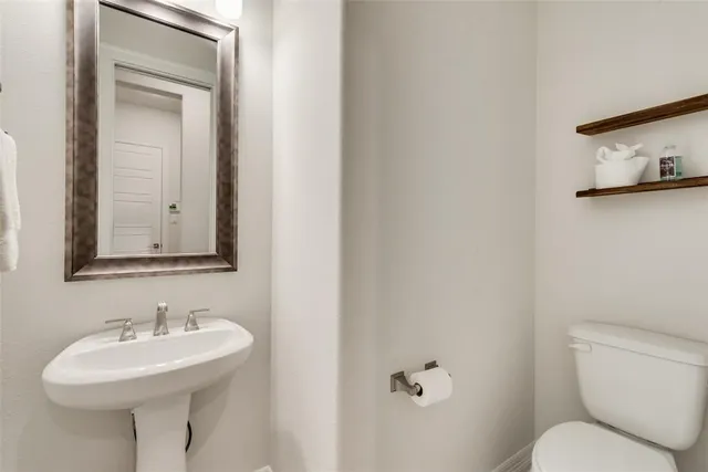 a bathroom with a toilet sink and mirror