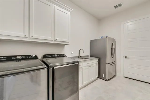 a kitchen with a refrigerator sink and cabinets