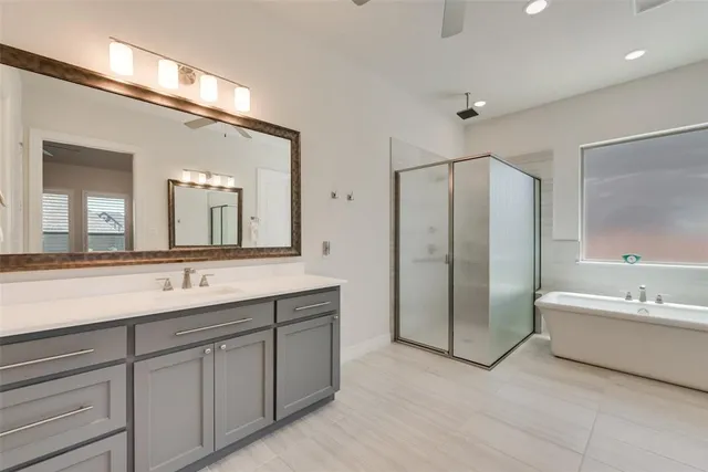 a spacious bathroom with a double vanity sink mirror and bathtub