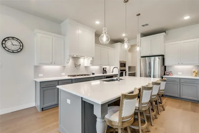 a kitchen with a dining table chairs sink and cabinets