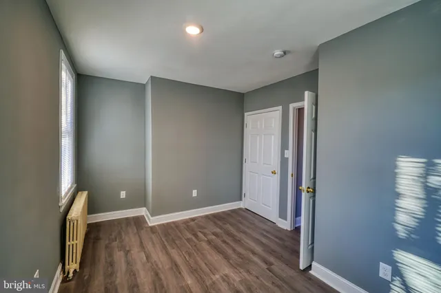 a view of empty room with wooden floor