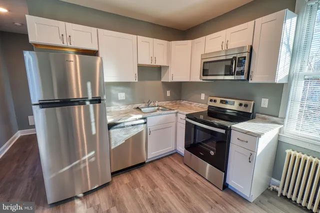 a kitchen with white cabinets sink and stainless steel appliances