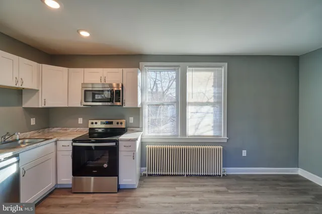 a kitchen with stainless steel appliances a stove a sink and a microwave