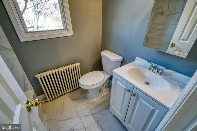 a bathroom with a sink toilet and a mirror
