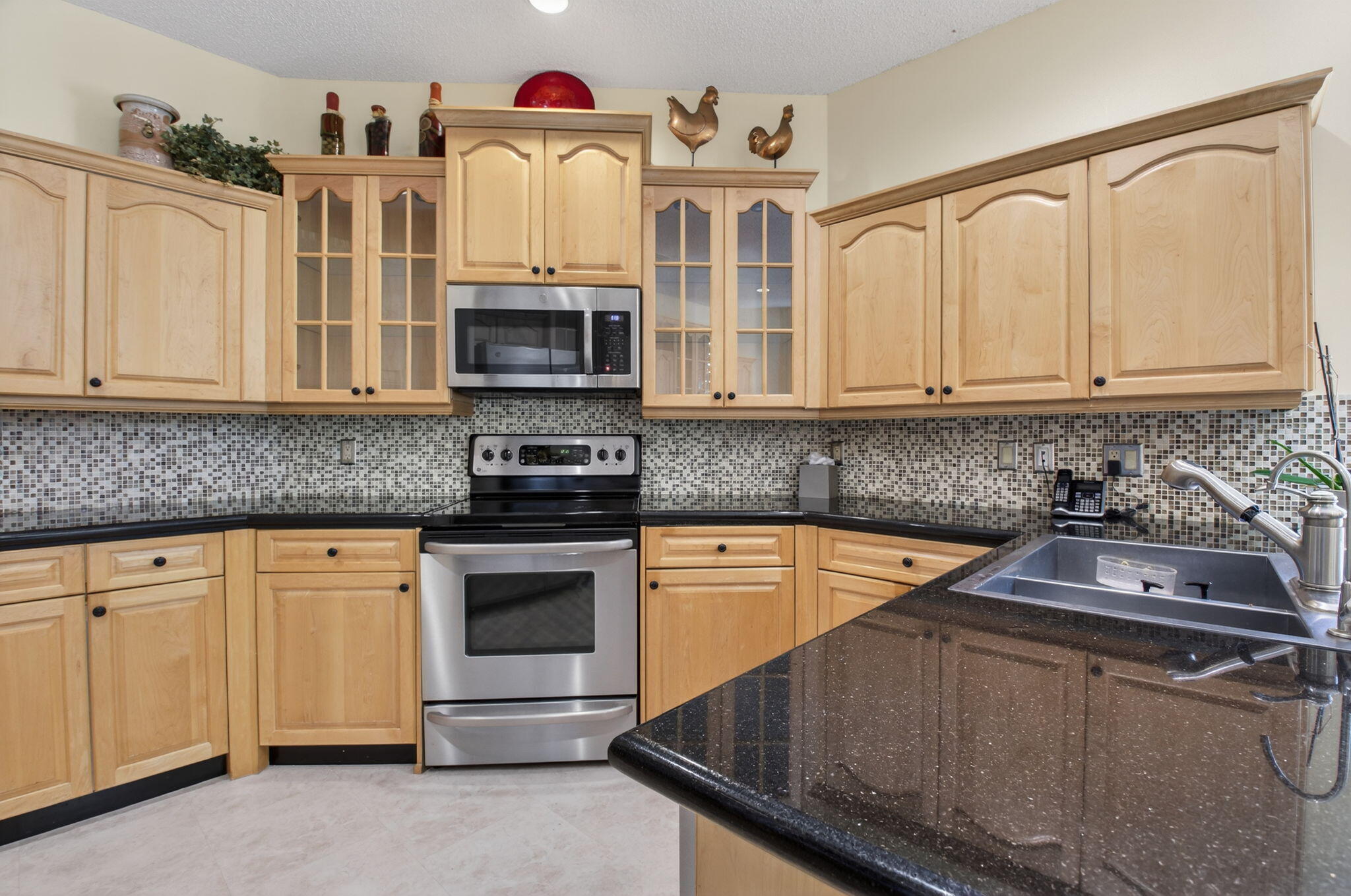 6395 Northwest 24th Avenue Boca Raton, FL 33496 - Photo 20 of 88 a kitchen with stainless steel appliances granite countertop a stove and white cabinets