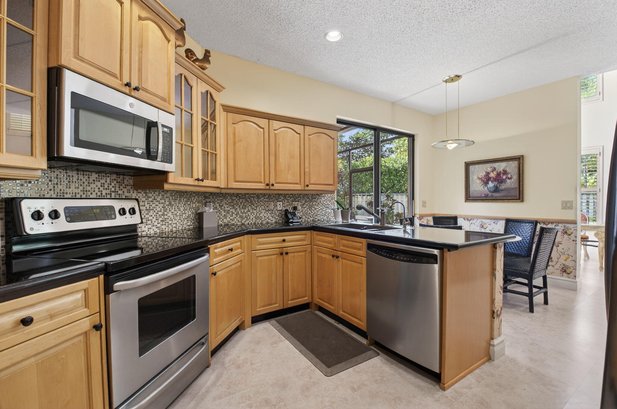 6395 Northwest 24th Avenue Boca Raton, FL 33496 - Photo 22 of 88 a kitchen with stainless steel appliances granite countertop a stove microwave and sink