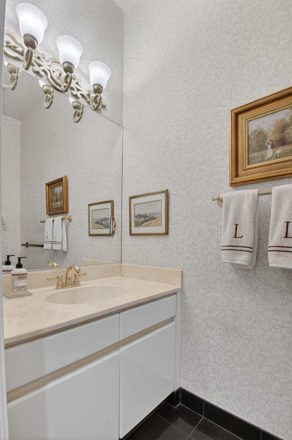 6395 Northwest 24th Avenue Boca Raton, FL 33496 - Photo 23 of 88 a bathroom with a sink a mirror and a painting on the wall