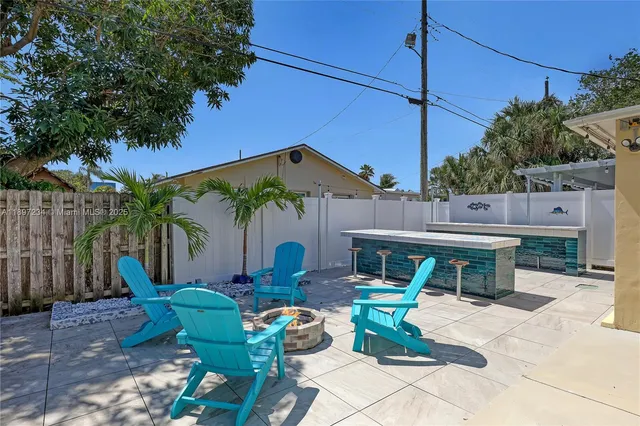 a backyard of a house with barbeque oven table and chairs