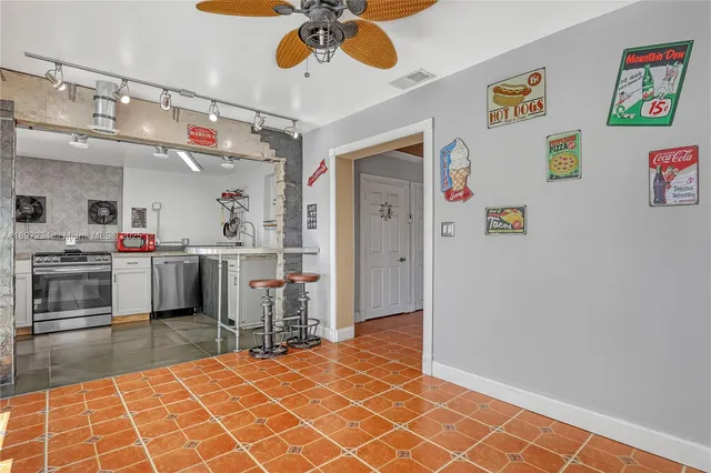 a kitchen with kitchen island stainless steel appliances a sink and cabinets