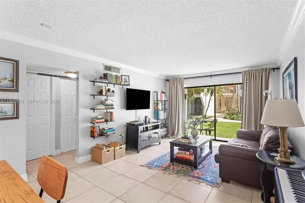 a living room with furniture a flat screen tv and a window