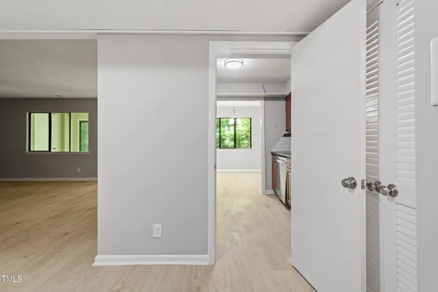 a view of a hallway with wooden floor and a living room
