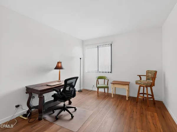 a view of a workspace with furniture and wooden floor