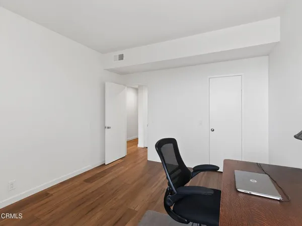 a view of a workspace with furniture and wooden floor