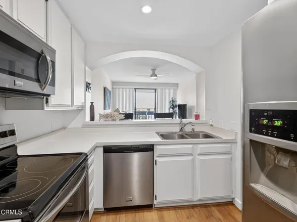 a kitchen with stainless steel appliances a sink stove and cabinets