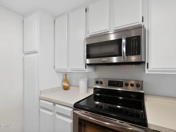 a kitchen with stainless steel appliances a stove a microwave and cabinets