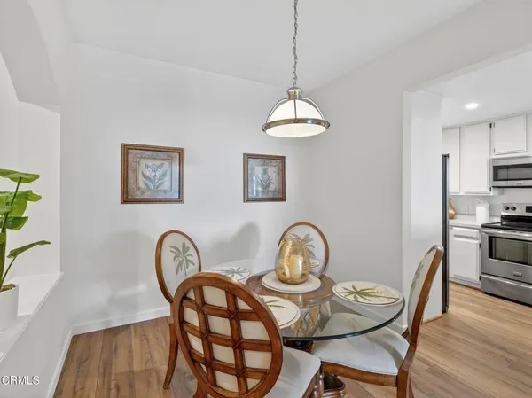 a view of a dining room and livingroom with furniture wooden floor a chandelier