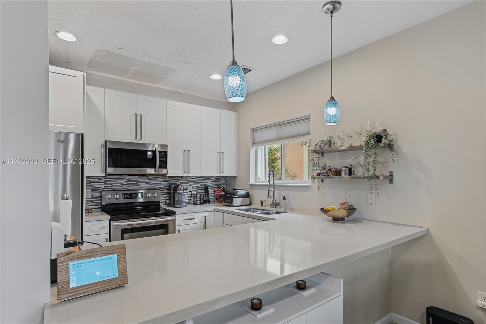396 Northeast 33rd Terrace Homestead, FL 33033 - Photo 17 of 42 a kitchen with a sink a stove and a microwave
