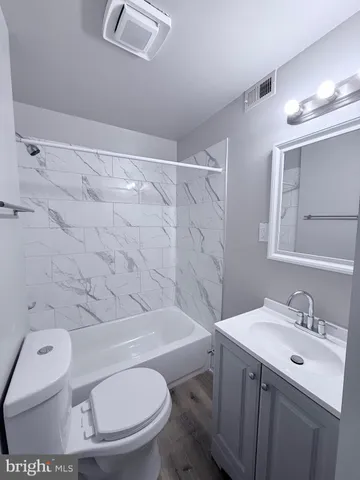 a bathroom with a toilet sink vanity and shower