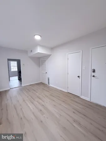 a view of empty room with wooden floor