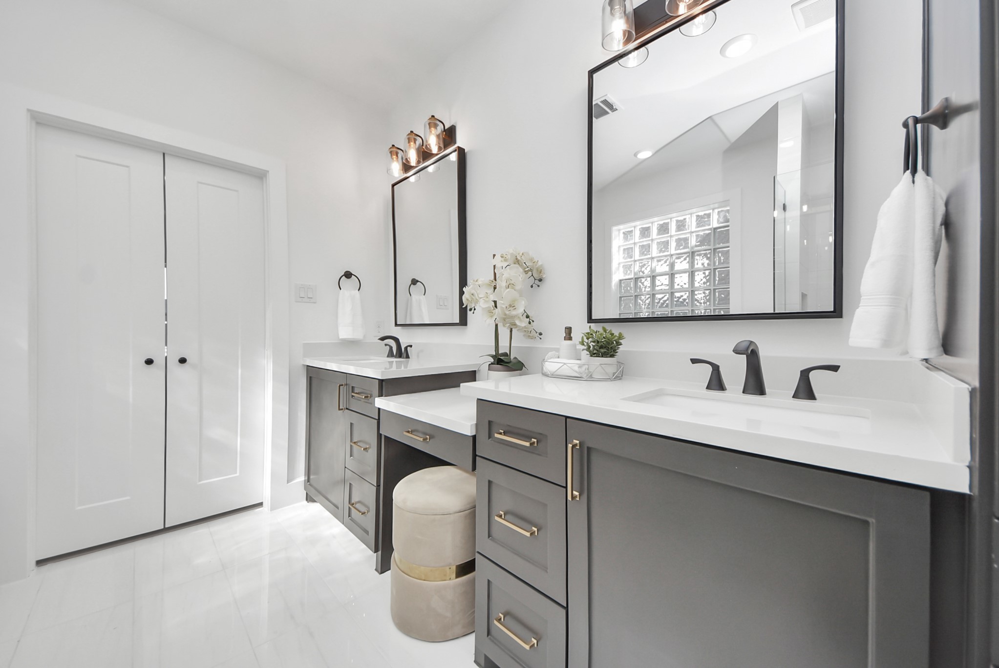 925 Fisher Street, Unit B Houston, TX 77018 - Photo 26 of 47 This bathroom features a sleek double vanity with black fixtures and ample storage. Neutral tones, large mirrors, and contemporary lighting contribute to a bright, elegant environment.