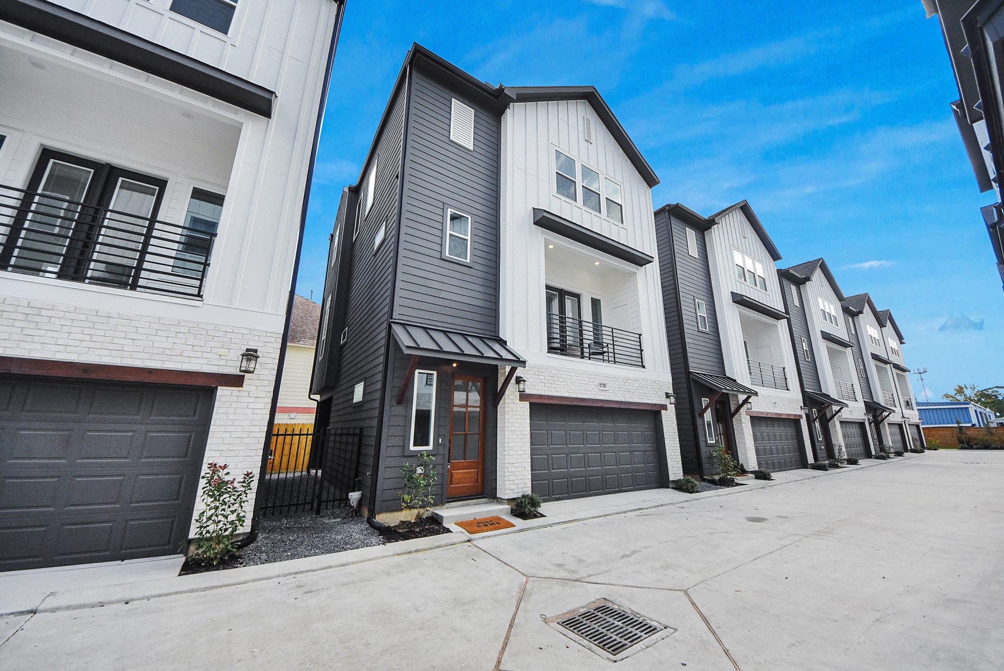 925 Fisher Street, Unit B Houston, TX 77018 - Photo 43 of 47 This modern townhouse welcomes you with a sleek exterior in white and dark gray siding, a warm wooden door, a two-car garage, and a balcony. A small landscaped area enhances curb appeal, making it perfect for contemporary living.