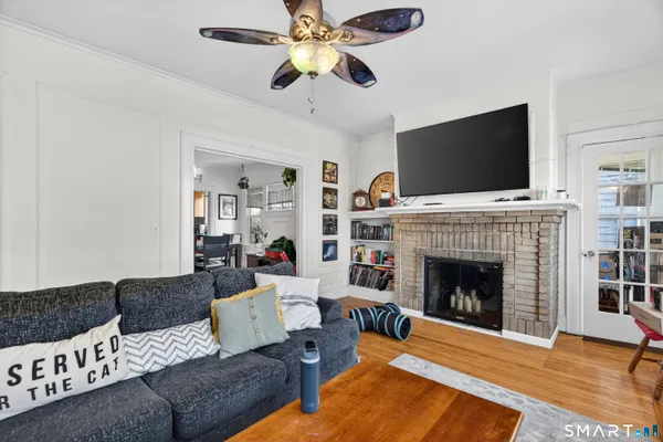 a living room with furniture a flat screen tv and a fireplace