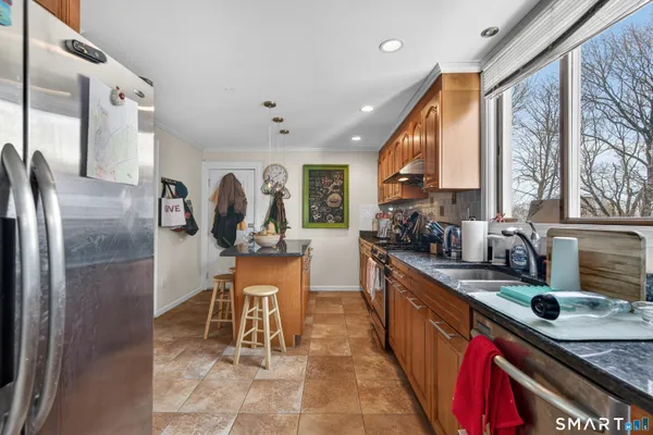 a kitchen with stainless steel appliances granite countertop a sink stove and refrigerator