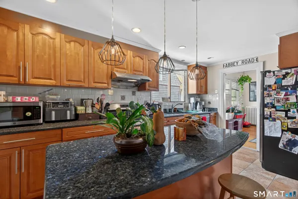 a kitchen with stainless steel appliances granite countertop a sink a counter space and cabinets