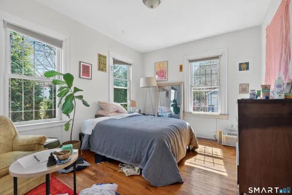 a bedroom with a bed and wooden floor