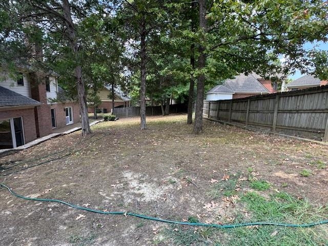 8668 Stablemill Lane Memphis, TN 38016 - Photo 25 of 36 a view of a backyard with large trees and wooden fence