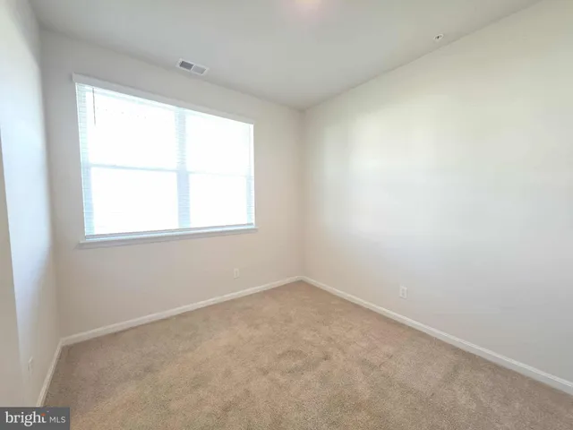 a large kitchen with a center island wooden floor stainless steel appliances and windows