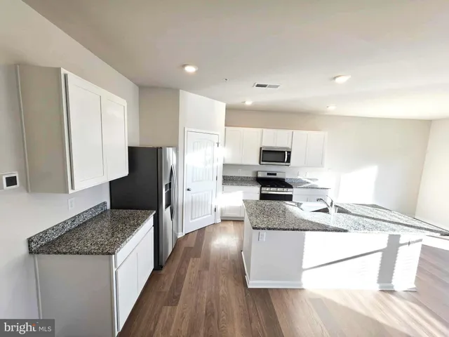 a kitchen with granite countertop stainless steel appliances and wooden cabinets