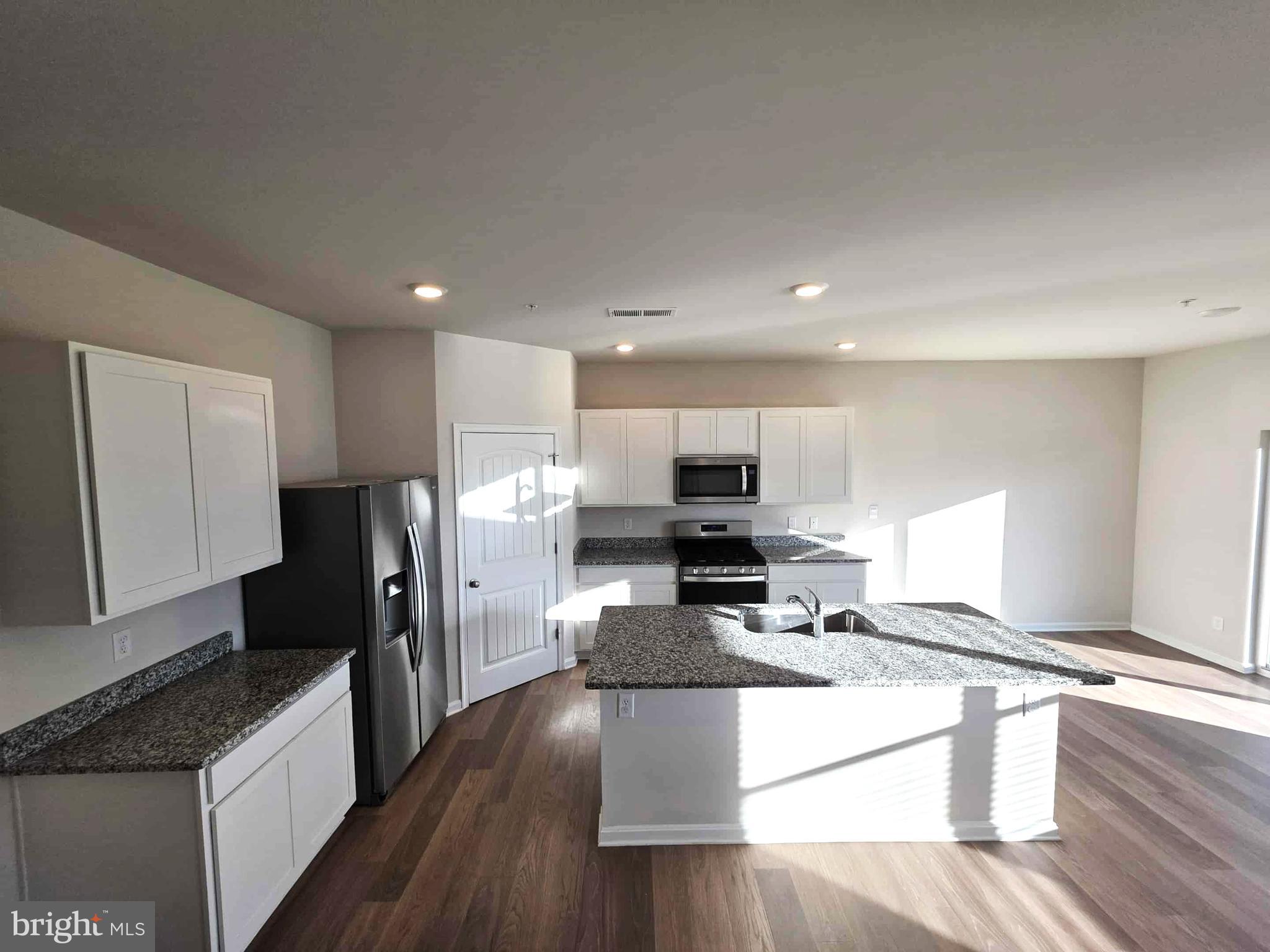 374 Robbins Farm Road Cambridge, MD 21613 - Photo 18 of 48 a large kitchen with stainless steel appliances a refrigerator a stove a sink dishwasher and a stove with wooden floor