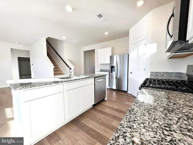 a kitchen with granite countertop a sink and steel appliances