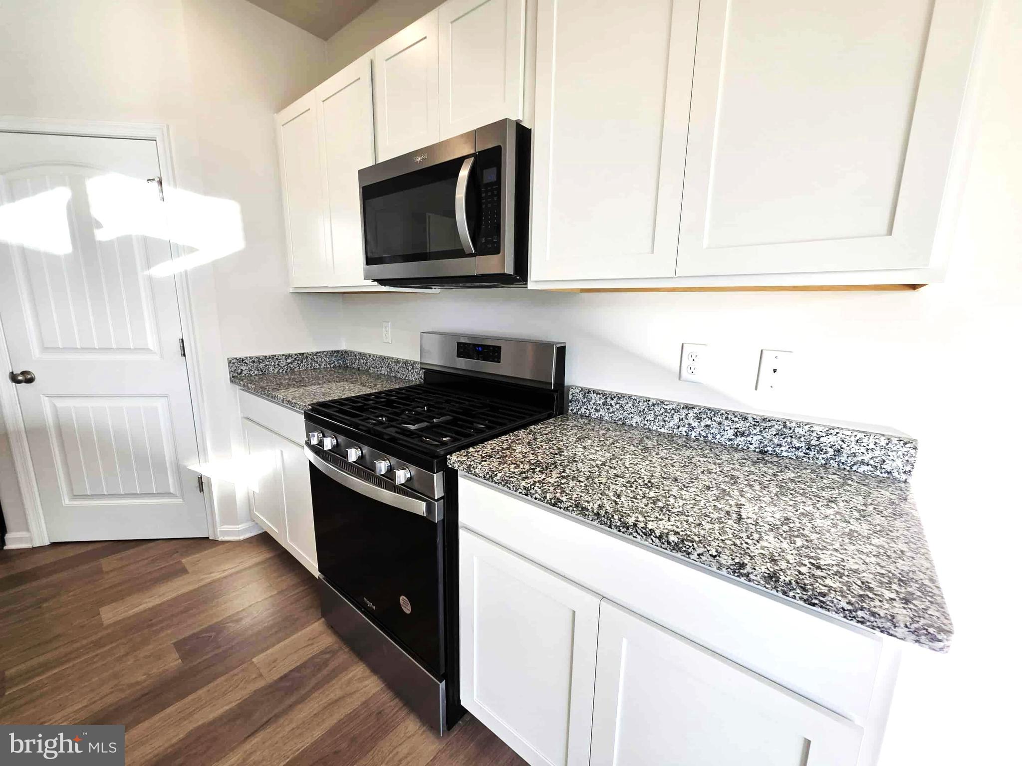 374 Robbins Farm Road Cambridge, MD 21613 - Photo 23 of 48 a kitchen with stainless steel appliances granite countertop a sink stove and microwave