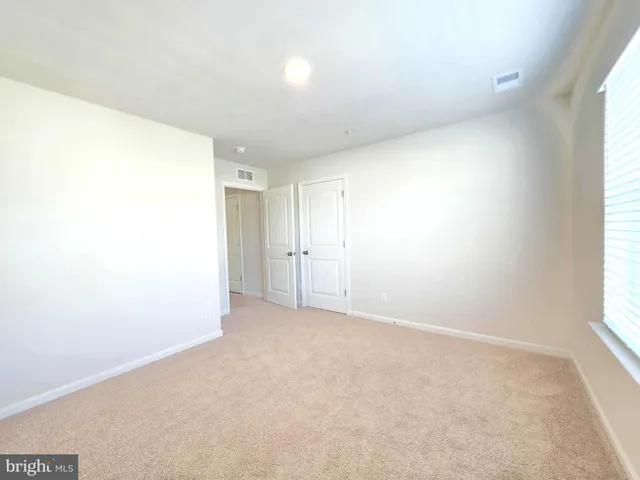 an empty room with windows and closet
