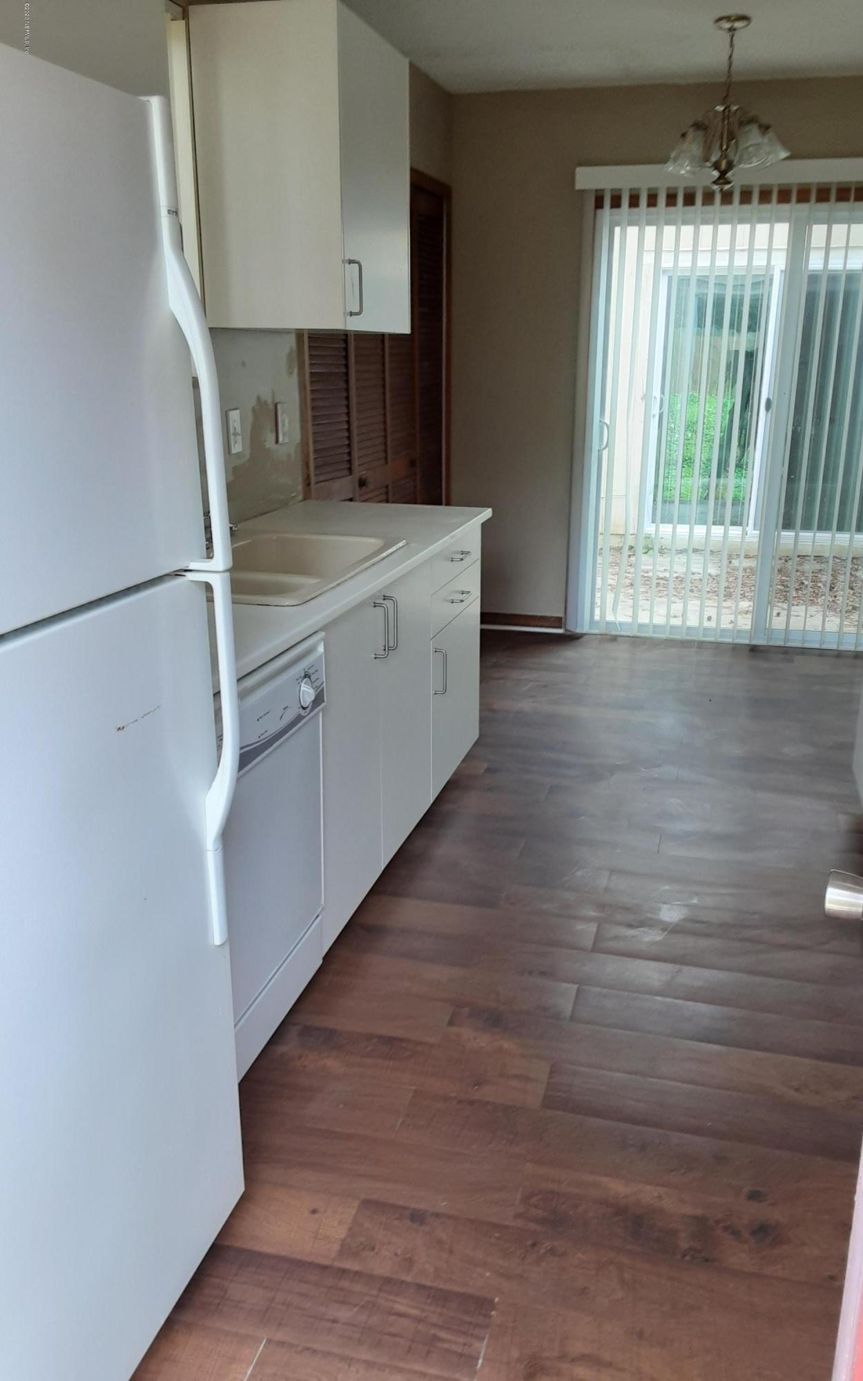 2100 Cornell Road Middleburg, FL 32068 - Photo 20 of 20 a kitchen with kitchen island a sink wooden floor and a refrigerator
