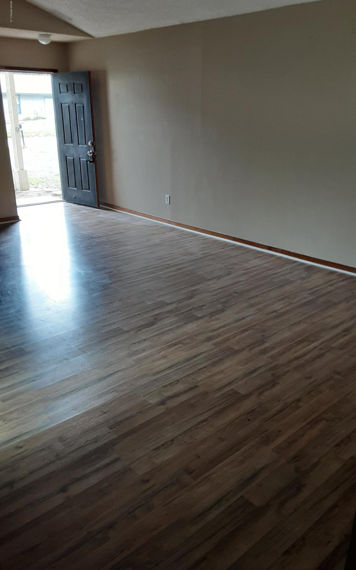 2100 Cornell Road Middleburg, FL 32068 - Photo 2 of 20 an empty room with wooden floor and windows