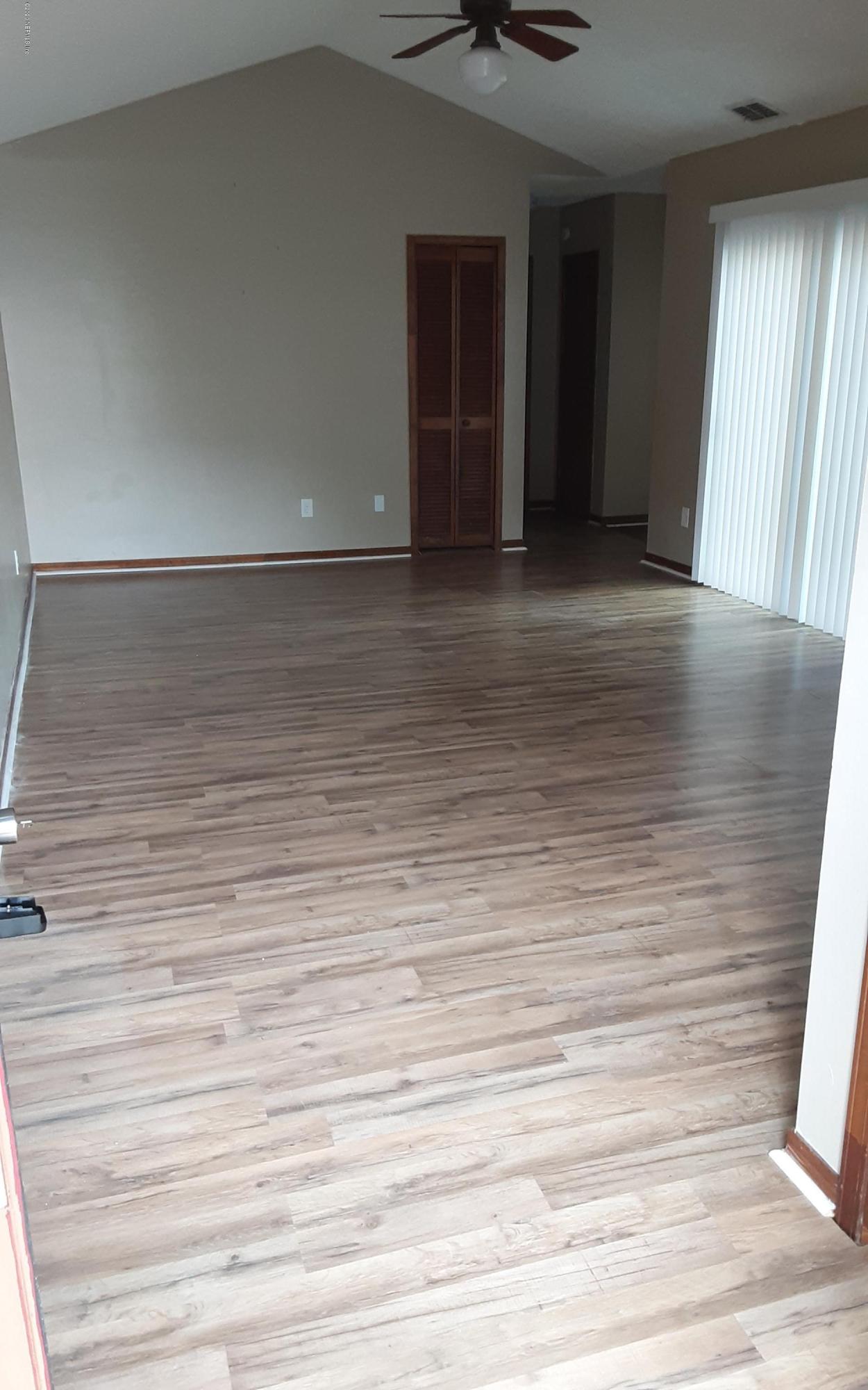 2100 Cornell Road Middleburg, FL 32068 - Photo 3 of 20 a view of an empty room with wooden floor and a window