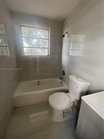 a white toilet sitting next to a bath tub shower