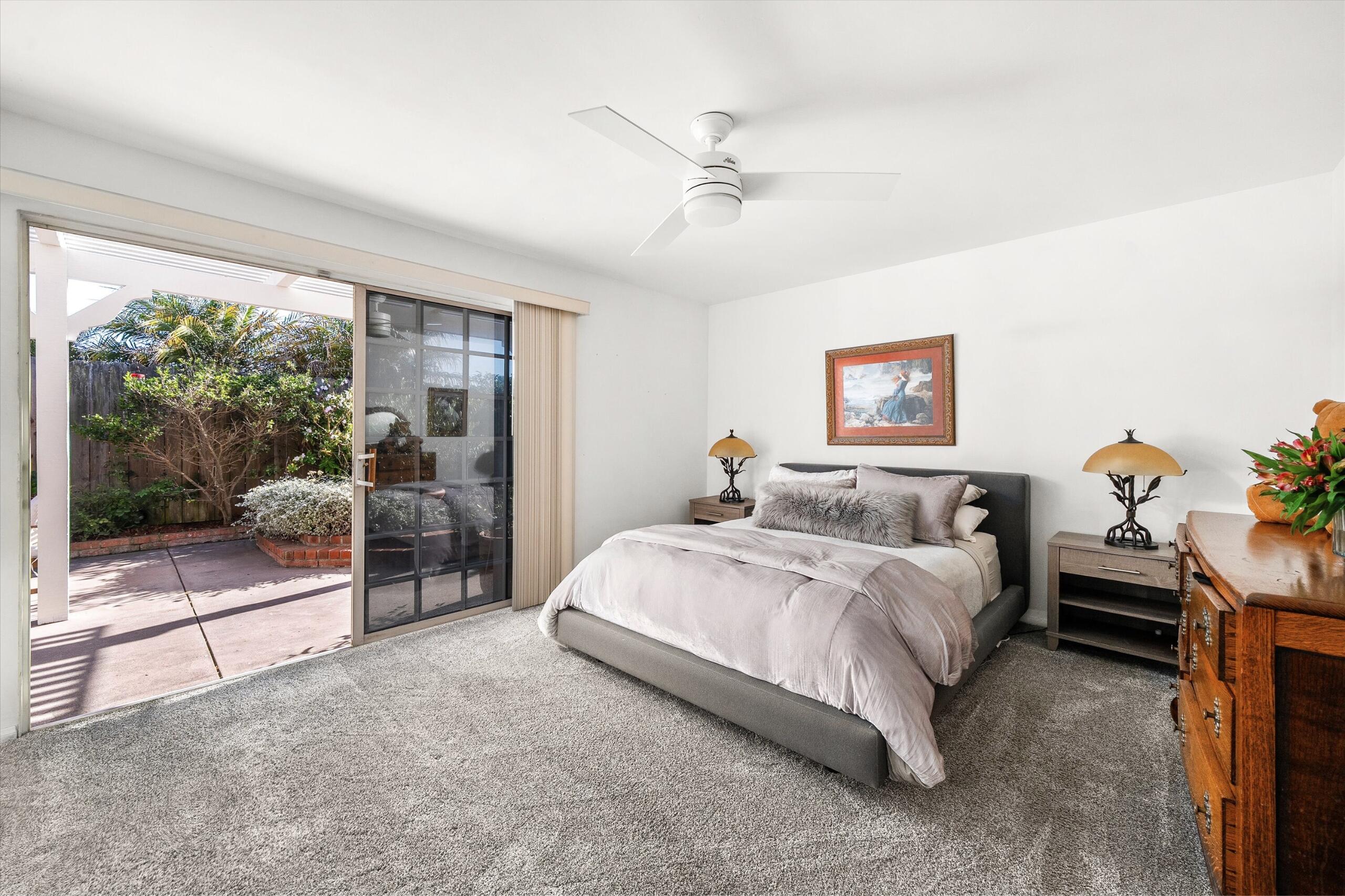 4565 Chapparral Drive Carpinteria, CA 93013 - Photo 11 of 23 a spacious bedroom with a bed and a chandelier