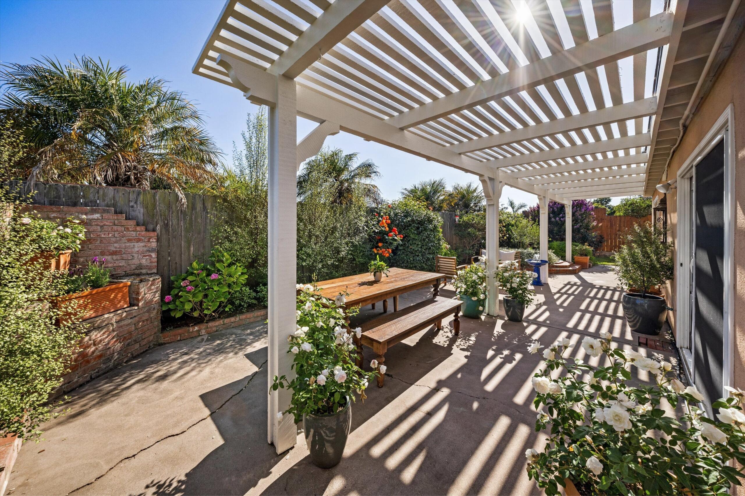 4565 Chapparral Drive Carpinteria, CA 93013 - Photo 17 of 23 a view of a patio with table and chairs potted plants with wooden floor and fence
