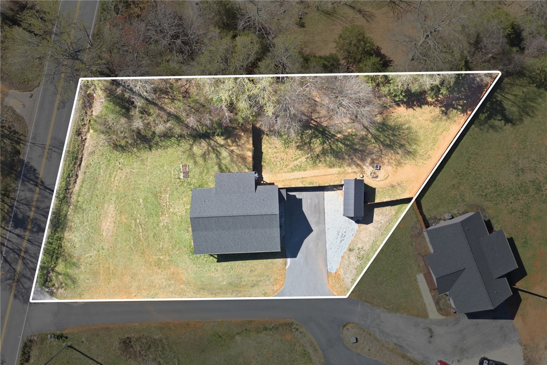 745 Dave Nix Road Seneca, SC 29678 - Photo 12 of 32 An aerial view captures the property's serene expanse, featuring a house with a surrounding lot and driveway.