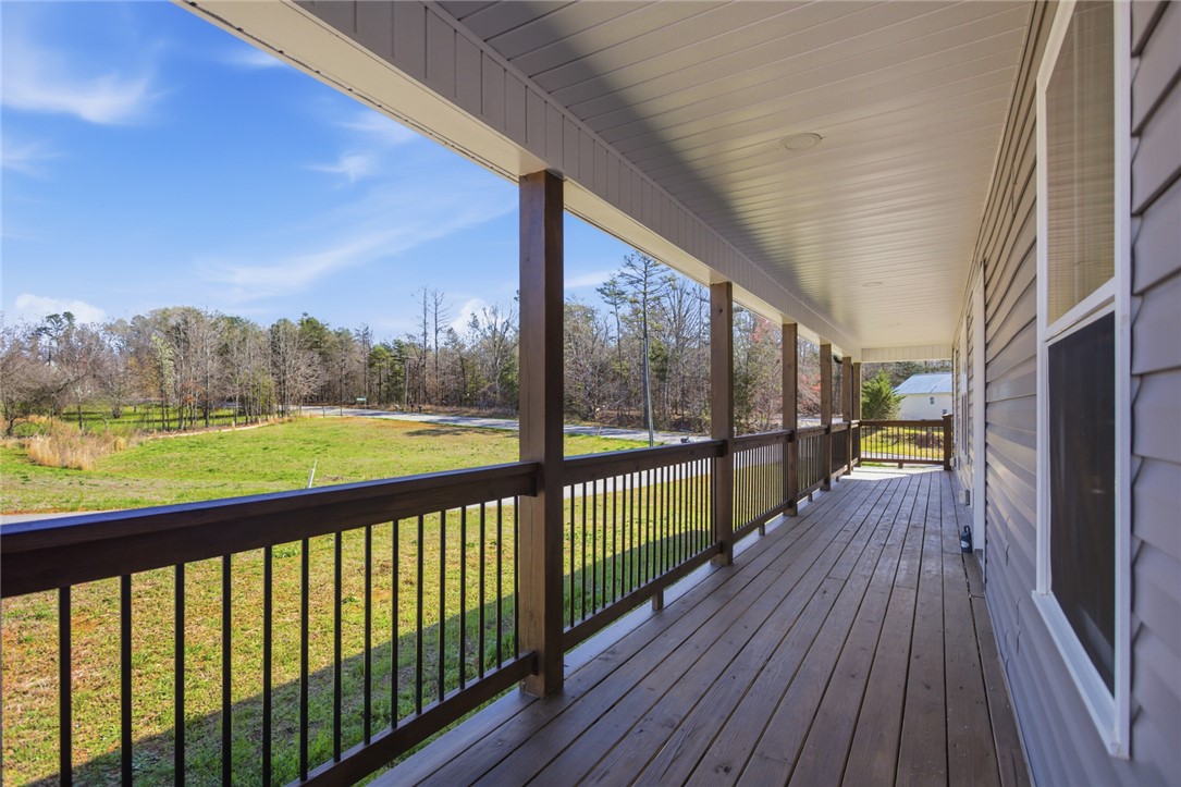 745 Dave Nix Road Seneca, SC 29678 - Photo 13 of 32 Enjoy peaceful outdoor moments on this expansive porch, offering scenic views of surrounding greenery.