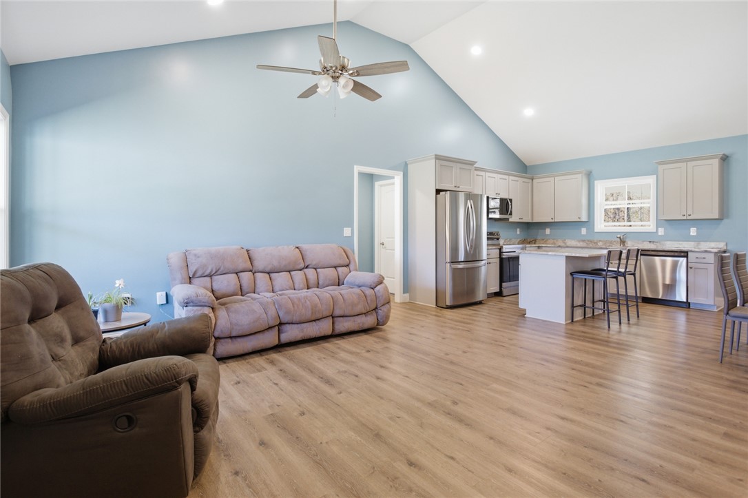 745 Dave Nix Road Seneca, SC 29678 - Photo 6 of 32 This airy open-concept living space features a kitchen island, modern appliances, and vaulted ceilings.