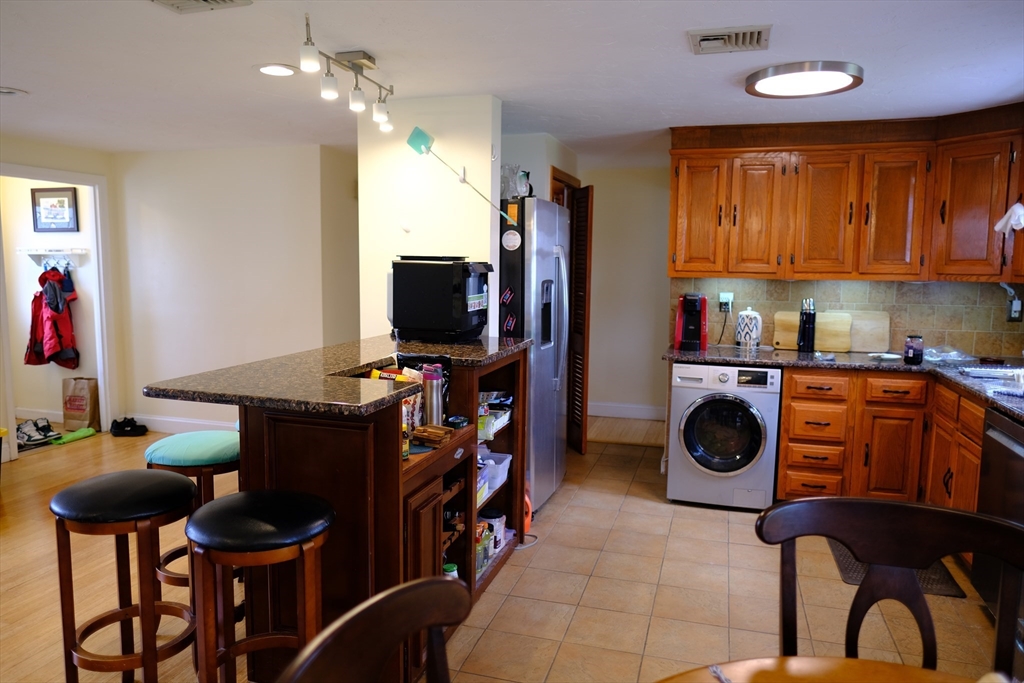 9 Stanley Street Natick, MA 01760 - Photo 15 of 42 a kitchen with stainless steel appliances a stove a sink dishwasher and a fireplace with chair