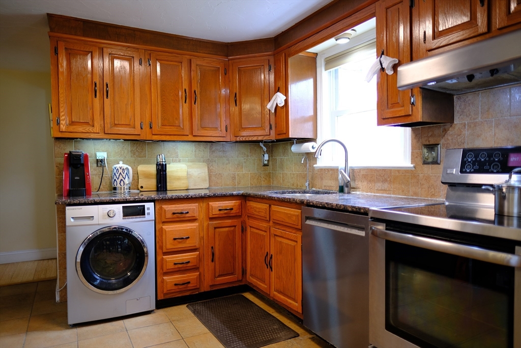 9 Stanley Street Natick, MA 01760 - Photo 16 of 42 a kitchen with stainless steel appliances granite countertop a sink stove and cabinets